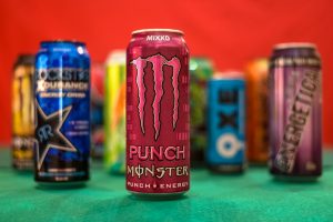 Pink Monster energy drink with other blurred Monster cans in the background