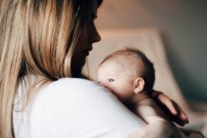 Woman in white shirt holding newborn