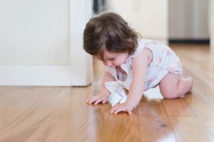 Baby crawling on wood floor