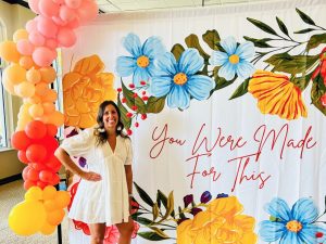 Woman in white dress standing in front of mural