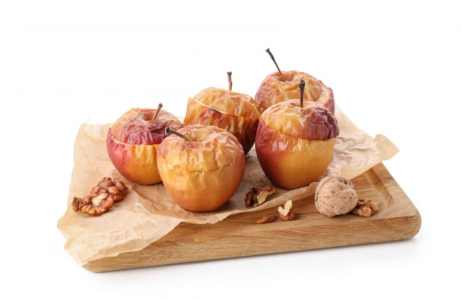 Baked apples sitting on a wooden cutting board