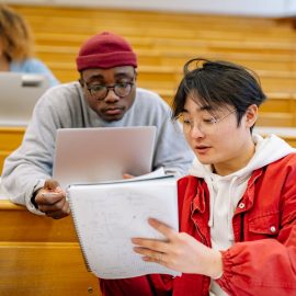Two boys studying in a college lecture hall.