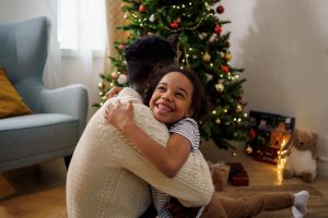 Dad and daughter hugging by Christmas tree