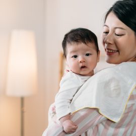 Woman holding cute Asian baby