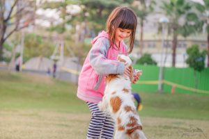 Little girl playing with dog outside
