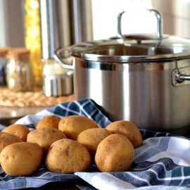 Image of pot with raw potatoes next to it on the counter