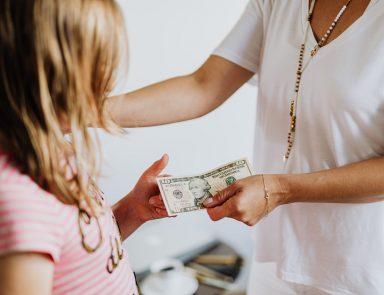 Mother handing daughter a $10 bill