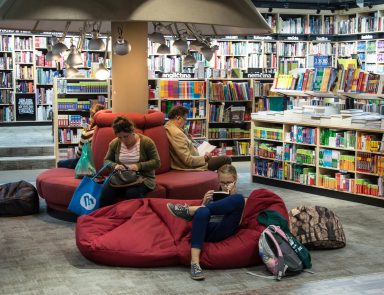 People sitting on bean bag chairs reading in a library