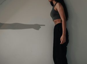 Shadow of an arm pointing at a girl's stomach