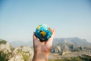 Person holding a mini planet Earth