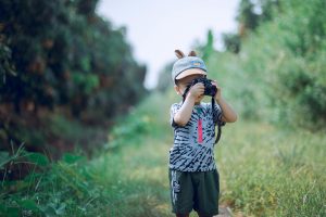Boy using camera outside at summer camp