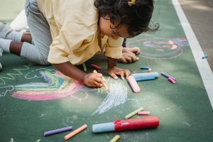 Girl coloring with sidewalk chalk