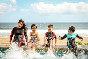 Family at beach splashing in water