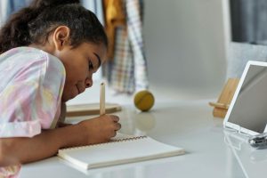 Girl writing in notebook doing homework