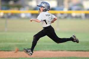 Child playing baseball running to the base