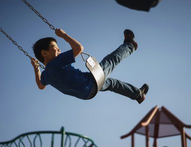 Child swinging on swing at park