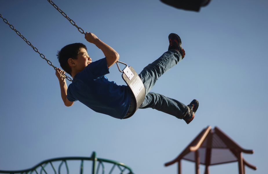 Child swinging on swing at park