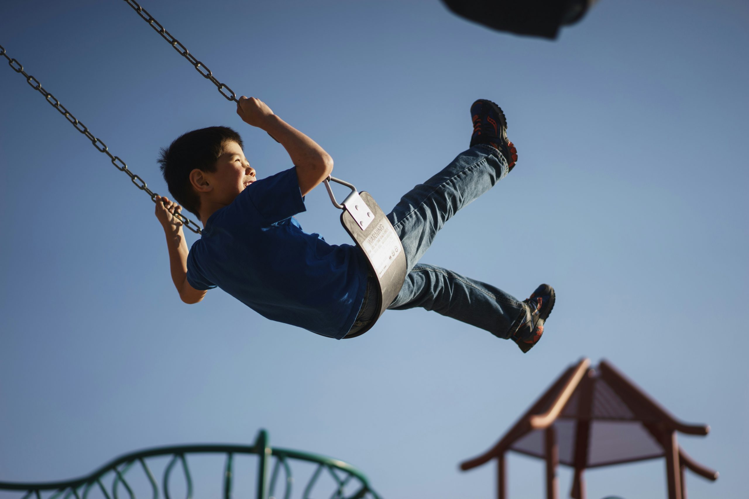 Child swinging on swing at park