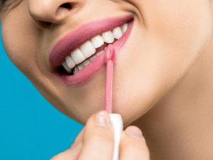 Woman putting on lipstick