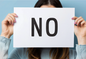Person holding piece of paper saying no