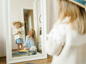 Mom and daughter trying on hat in the mirror